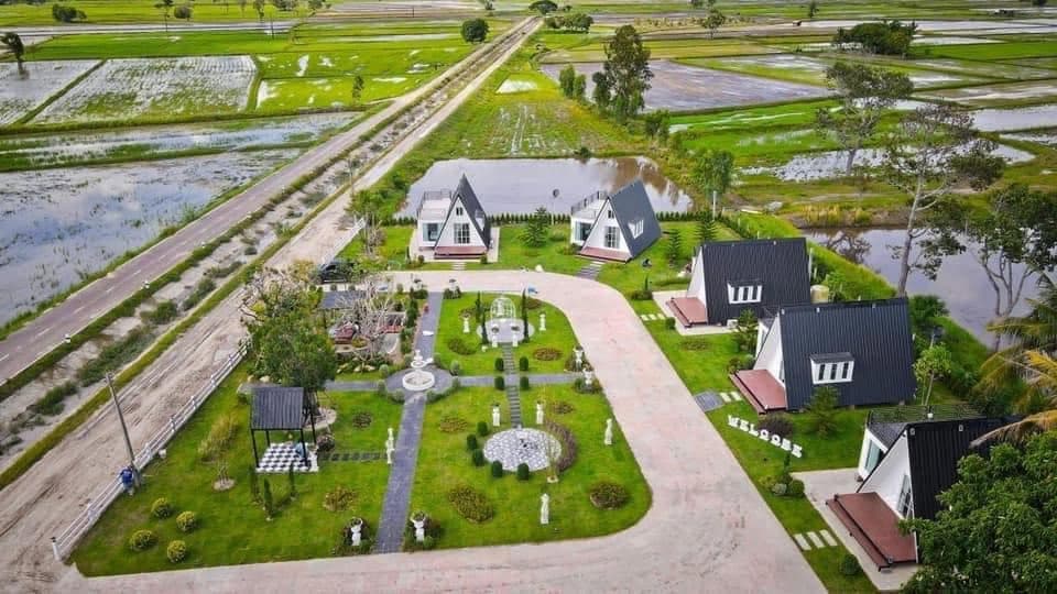 ภาพมุมสูงของ Natcha Villas บ้านพัก A-Frame เรียงรายกลางทุ่งนา