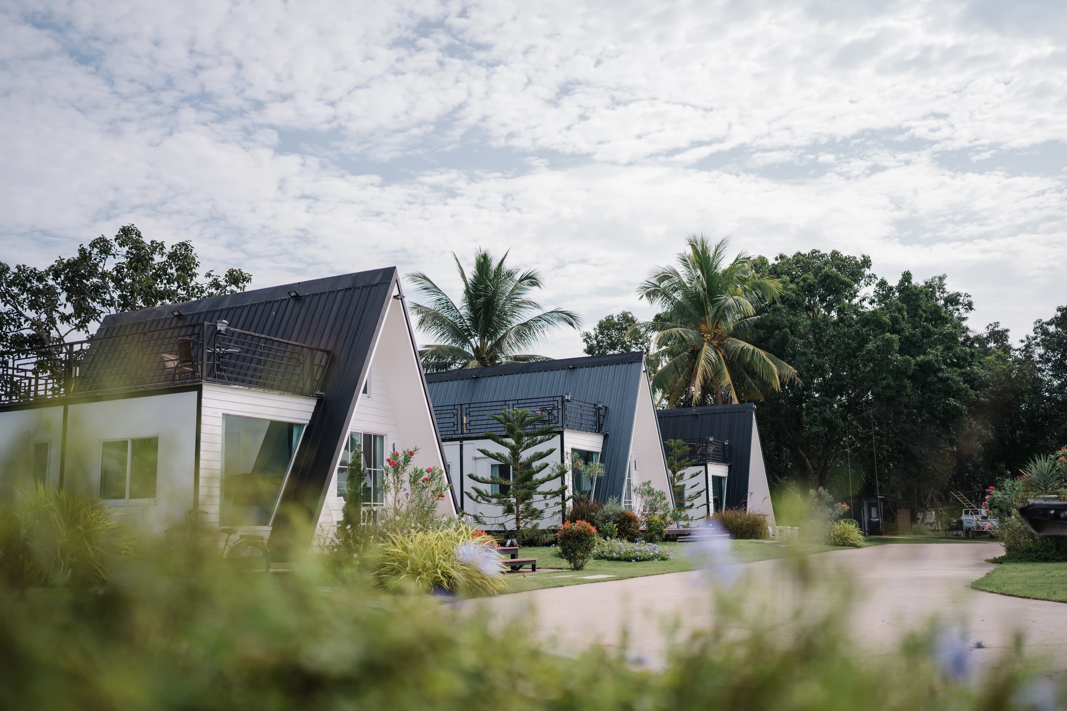 White A-frame villa in a garden at Natcha Villas